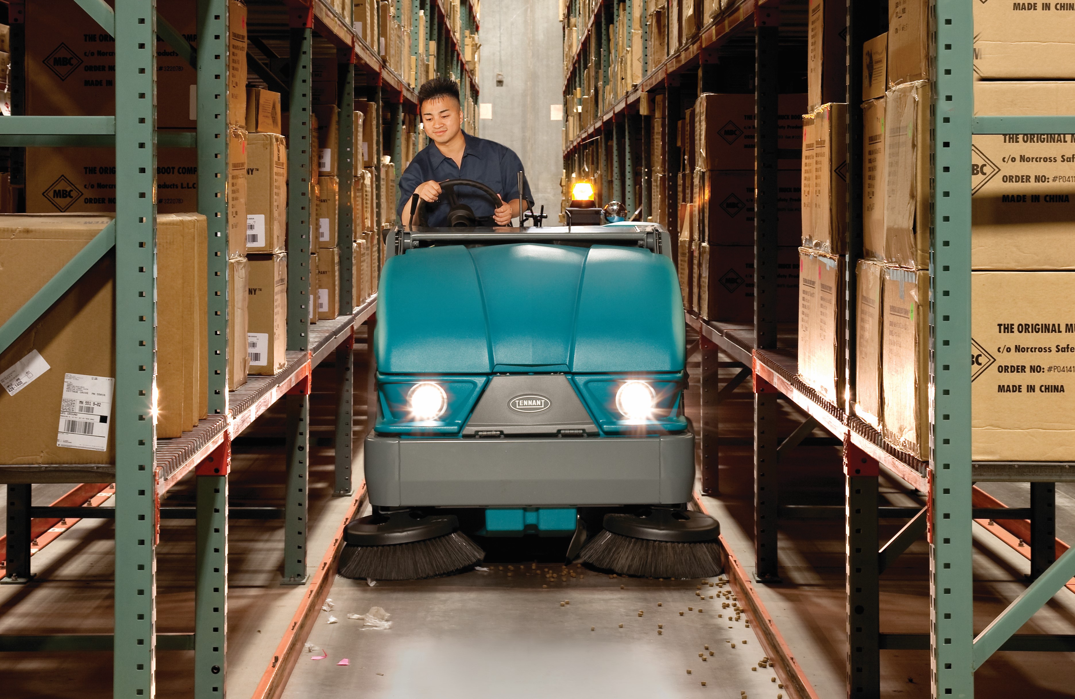 Tennant opzit veegmachine maakt schoon tussen twee stellingen